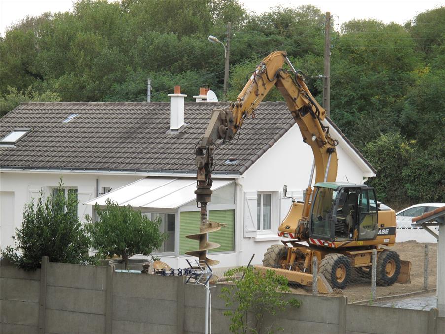 P� en tomt intill borrade man med en stor jordborr