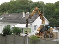 P� en tomt intill borrade man med en stor jordborr
